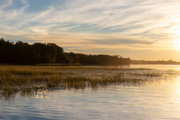 Lake scene at sunset with colorful clouds and water mist
