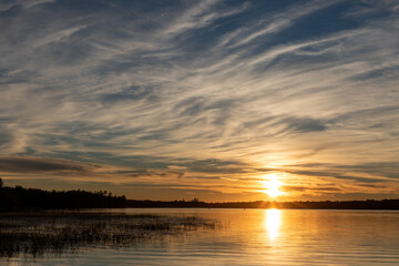 Fototapeta na wymiar Brilliant lake sunset with textured sky