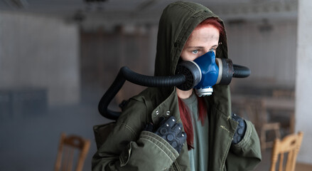 Naklejka premium Post apocalyptic concept. Woman in gas mask in abandoned building.