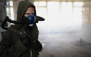 Young pandemic survivalist woman in gas mask looking in front of her on the background with...