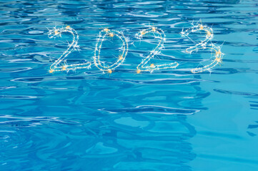 Happy New Year 2023. Sparkling burning numbers Year 2023 on clear water background. Beautiful...