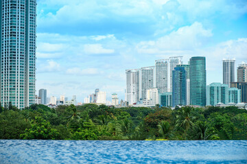 Fototapeta premium View of the skyscrapers of the city of Manila from the pool on the high floor. Empty pool without tourists.