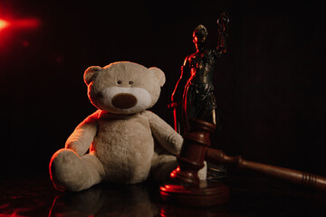 Figure of lady justice and teddy bear. Abuse in family and law protection children concept