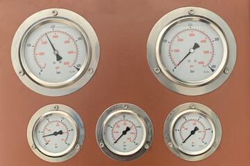 Hydraulic pressure gauge with  on a control panel with other meters.