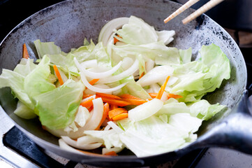 中華鍋で野菜を炒める