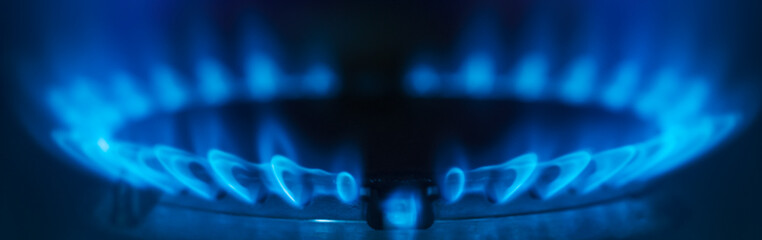 Close-up natural gas flame. Gas flame on dark background. Blue flames from gas stove burner - obrazy, fototapety, plakaty