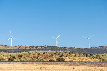 Solar energy panel photovoltaic cell and wind turbine farm power generator in nature landscape.