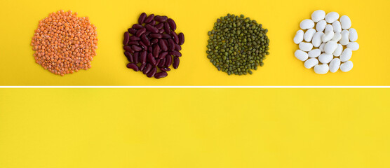 Banner. Top view of lentils, beans and mung on the yellow background. Copy space.