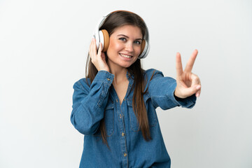 Fototapeta premium Young caucasian woman isolated on white background listening music and singing