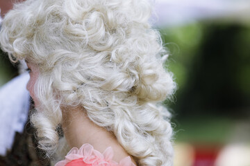 Shallow depth of field (selective focus) details with a vintage blonde wig on the head of a model.