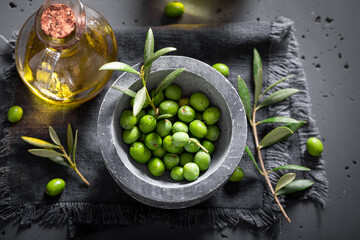 Healthy and fresh raw olives with olive berries on branch.