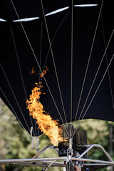 A man uses a double gas burner to inflate a hot air balloon.