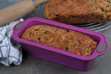 Cakes maison dans un moule en silicone et sur une volette à gâteau avec des ustensiles de cuisine