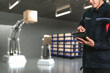 Asian Man Engineer hold smartphone touch touching UI screen interface for manufacturing industry technology Product export and import future Robot cyber warehouse arm robot future technology