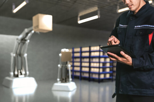 Asian Man Engineer hold smartphone touch touching UI screen interface for manufacturing industry technology Product export and import future Robot cyber warehouse arm robot future technology - Powered by Adobe
