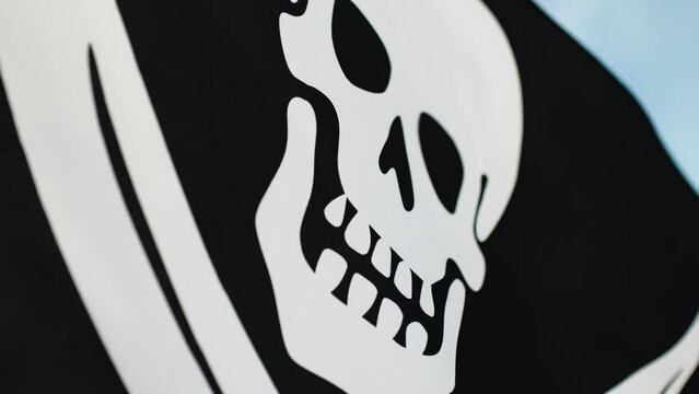 The skull symbol on pirate black flag on the ocean