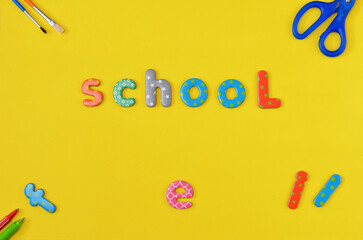 the word school from the letters of the children's alphabet on yellow background