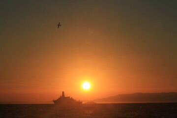 sunset and silhouette army ship