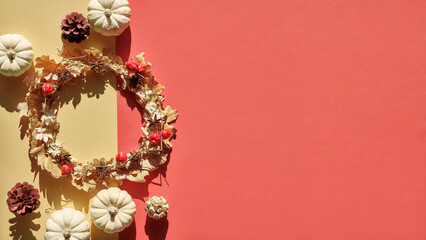 Dried floral wreath from dry Autumn leaves and Fall berries. Flat lay, top view from above with dry twigs and oak leaves on orange and golden paper. Copy-space, place for text.