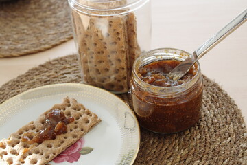 Fig jam and diet biscuit jar, Breakfast snacks on wooden table,  English breakfast and homemade fig marmalade, Selective focus.