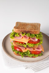 Club sandwich with ham, cheese, tomato and lettuce. 