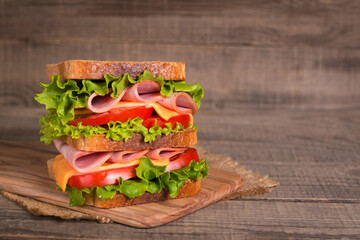 Club sandwich with ham, cheese, tomato and lettuce. 