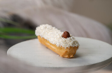 french eclair with coconut crumble hazelnut on a white desk