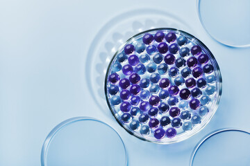 Sample of gel bubbles in petri dish on blue background, hard shadows. Abstract science, medicine...