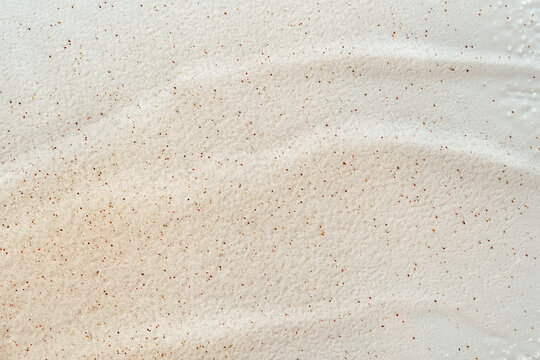 Beauty gel texture with particles. Beige background with brush strokes and particles
