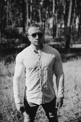 Black and white photo of cheerful man look empty space wear sunglass outdoor. Holiday