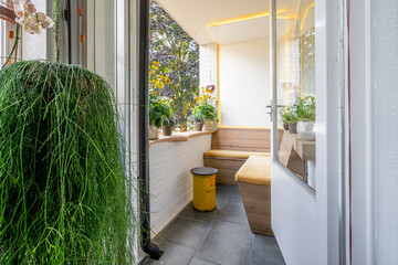 Interior with slatted window and a lot of plants and yellow design