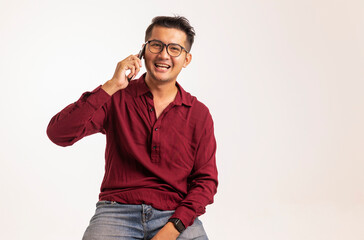 Smart Asian man using smartphone in studio background, handsome young Asian man smiling happily in formal shirt. using a smartphone to exchange or chat
