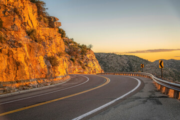 Drive up a winding road along rocky cliffs at sunset in Mount Lemmon Arizona
