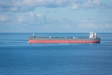 Cargo ship, bulk carrier sailing through the calm ocean. 