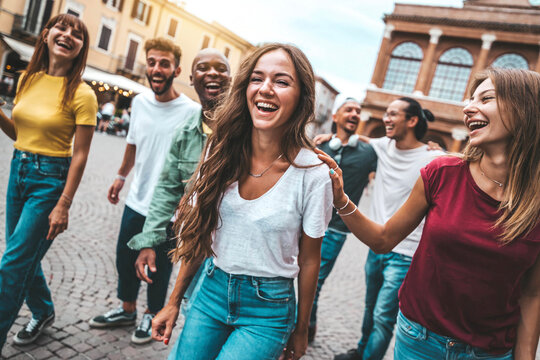 Multiracial group of friends hanging out together in the city center - Happy young people having fun walking outdoors - Friendship concept with guys and girls enjoying weekend vacation