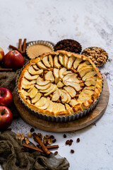 Homemade delicious apple cake with raisins and cinnamon over stone background, top view