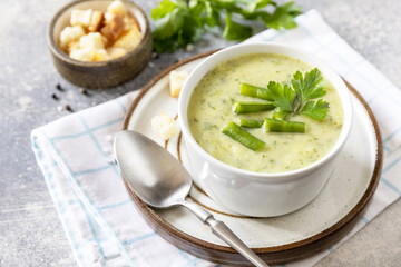 Healthy food. Vegan soup puree of green vegetables. Bowl of green bean and zucchini cream soup on a stone table.