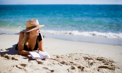 summer holidays background with woman reading on the beach