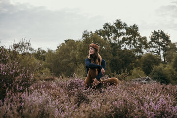 Fototapeta premium woman sat outdoors looking peaceful, with muted autumnal tones