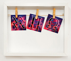 Air signs Gemini, Libra and Aquarius, a white frame with zodiac signs hung on a clothesline with...