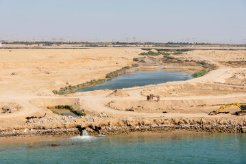 Landscape of the Suez Canal, view from the transiting cargo ship.