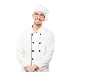 Happy young chef posing against background