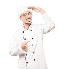 Happy young chef with a gesture of looking away