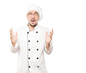 Crazy young chef making a gesture of despair