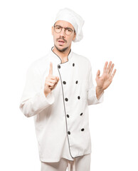 Haughty young chef making a contemptuous gesture