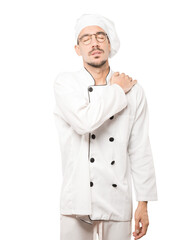 Concerned young chef with a gesture of pain