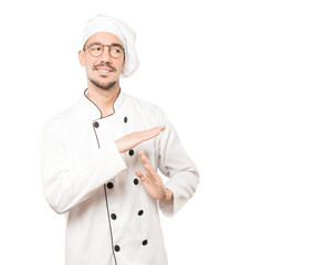 Stressed young chef making a time out gesture with his hands