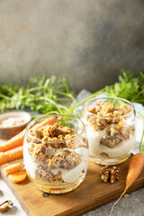 Healthy dessert. Vegan gluten-free pastry. Carrot cake with walnuts and cinnamon in a glass on a light background. Copy space.