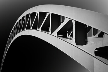Abstract black-and-white image of arch of modern steel bar arch bridge, isolated