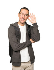 Happy student smiling and making a gesture of trying to hear something